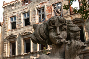 the famous sculpture of a girl on background of the house of the lions.