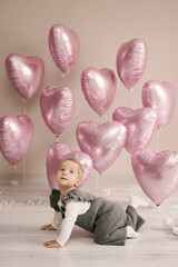 Cute little girl, 1st birthday, baby with helium balloons pink hearts