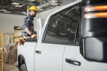 Contractor Sitting in Pickup Trunk at Construction Site © Tomasz Zajda
