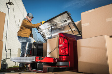 Professional Mover Loading Boxes on His Pickup's Cargo Bed - obrazy, fototapety, plakaty