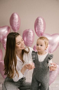 Cute little girl, 1st birthday, baby with mom and pink balloon hearts, balloon photo zone