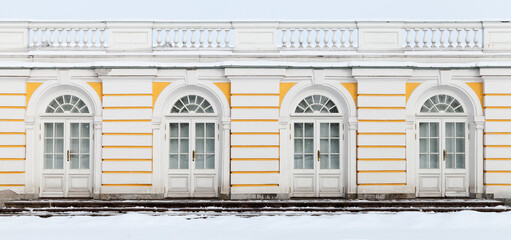 Old white wooden doors in yellow outdoor wall, background photo