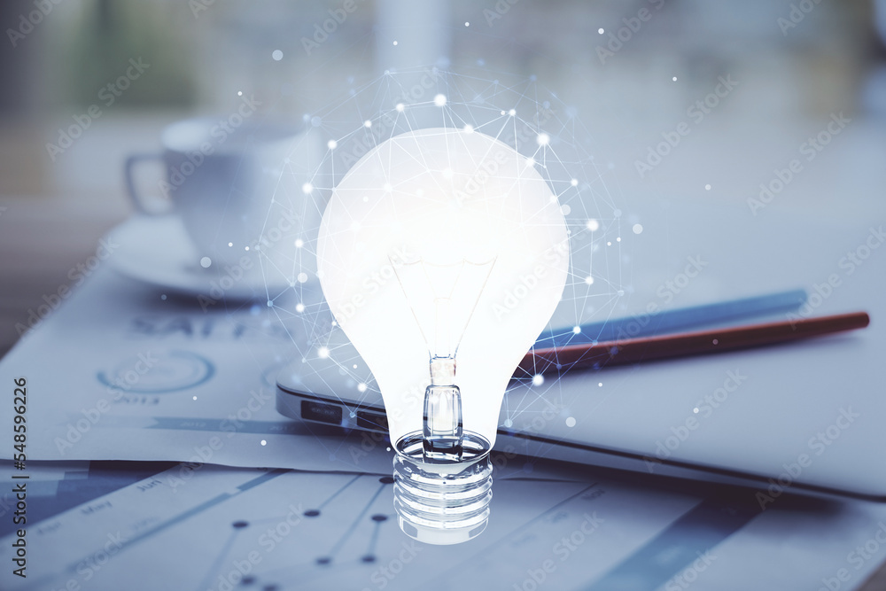 Poster Computer on desktop in office with bulb icon hologram. Double exposure. Concept of idea.