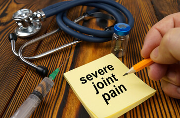 On the table is a stethoscope, a syringe and a sticker with the text - severe joint pain