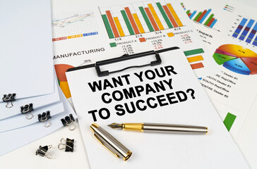 On the table among financial graphs and charts lies a tablet with the inscription - WANT YOUR COMPANY TO SUCCEED