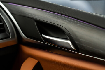 Fototapeta na wymiar Modern car interior door handle close up. Metallic Car door opener handle inside.