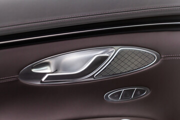 Modern car interior door handle close up. Metallic Car door opener handle inside.