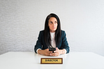 Young caucasian brunette business woman director in office thoughtful entrepreneur hold phone make decisions think before text r mock up isolated