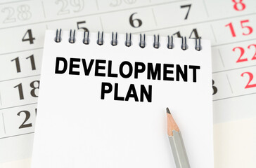 On the calendar is a notebook with the inscription - Development plan