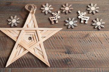 Wooden star, snowflakes, figurines lie on an aged wooden table, save space