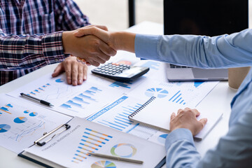 Young Asian businessmen and women shake hands as a team or greet each other at the office after a project. Successful in real estate business, finance, and new business ideas.