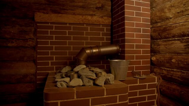 Interior of Finnish sauna, stove with chimney and stones. Russian bathroom. Wooden interior baths, wooden benches and loungers accessories for sauna, spa complex.