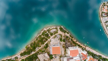 Aerial top shot of the Azure sea coastline with cloudscape reflection