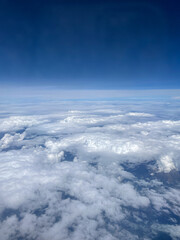 Stunning view of the expanse of land and sky, shot from thousand feet above the ground among white clouds. Smartphone photography
