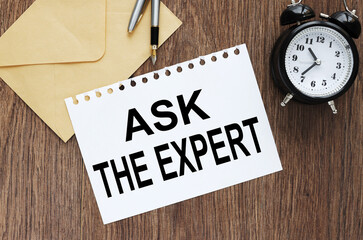 ASK AN EXPERT Concept. text on paper on an envelope on the desktop