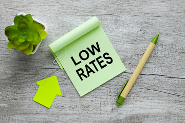 Low Rates text on green sticky note on desktop near potted plant