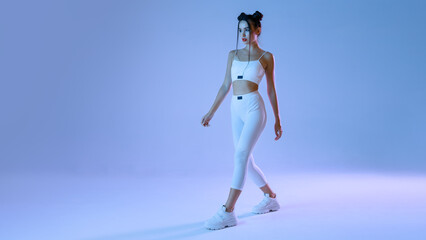 Woman in futuristic costume. Augmented reality game, future technology, AI concept. VR. Neon blue and red light. Blue background.