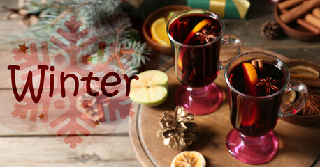 Obraz na płótnie Canvas Banner with tasty mulled wine and text WINTER on wooden background