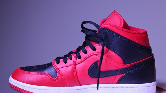 Fashionable red Nike Jordan boots on a purple background