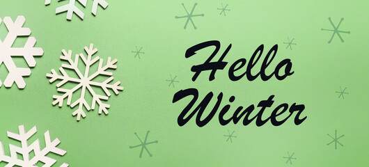 Banner with snowflakes and text HELLO WINTER on green background