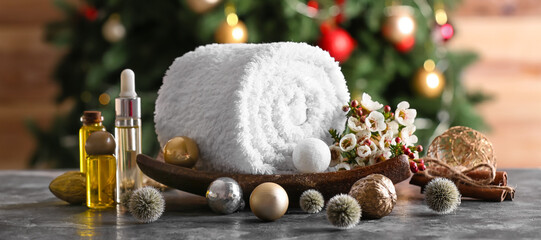 Christmas composition with towel and essential oils for spa treatment on table