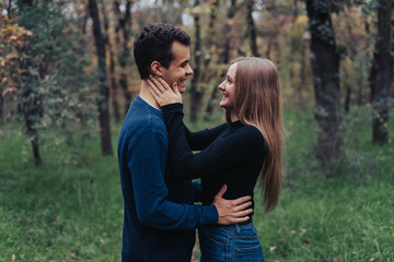 Young cheerful couple in a park, forest