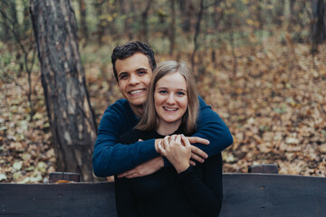 Young cheerful couple sitting on a bench in a park