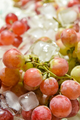 Bunch of ripe grapes in ice, closeup