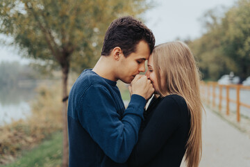 Young couple kissing hands in a park