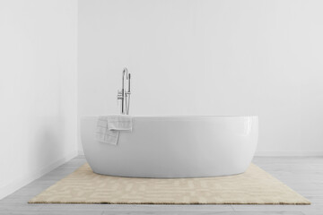 Modern bathtub in light bathroom interior