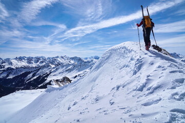 Naklejka na ściany i meble Skitour, Skibergsteiger im Aufstieg am Gipfel