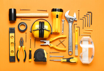 Hearing protectors with builder's tools on color background