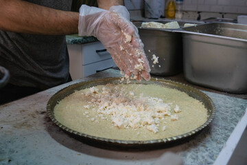 Adding cheese to Kunefe