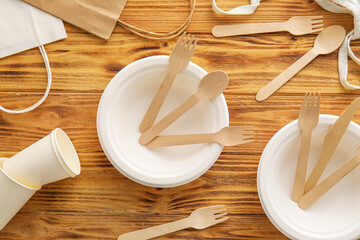 Eco tableware and different bags on wooden background