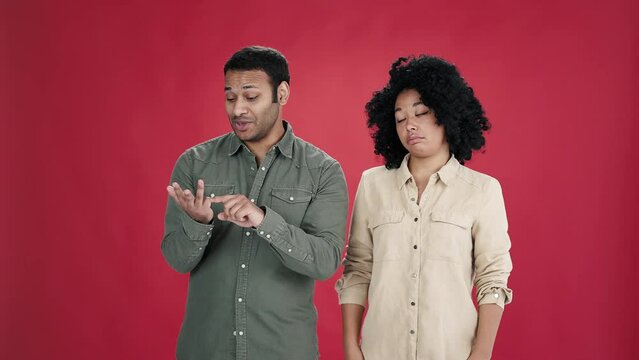 Man speaks bending fingers and looks at woman questioningly