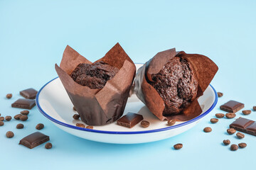 Plate with sweet chocolate muffins on color background