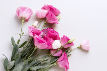 Delicate bouquet of pink and white eustoma flowers. An elegant, delicate bouquet of lisianthus lies on a light background.