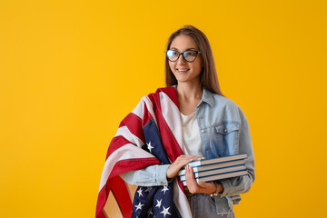 Beautiful woman with USA flag and books on yellow background
