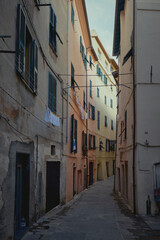 A narrow street with colourful buildings and laundry hung to dry in an old town in Europe. Ventimiglia, Italy