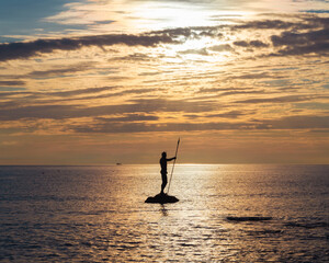 Sea freight, sea holidays. Neptune or Poseidon statue stands in sea at sunset
