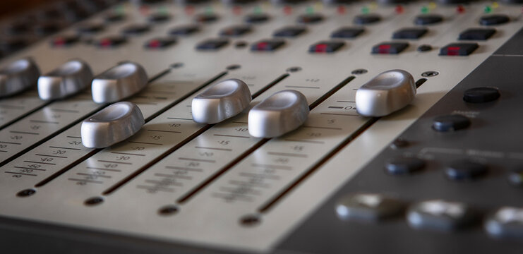 Faders and buttons on an audio post production console for DAW, Pro Tools, music and radio