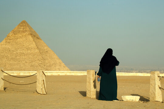 A mulher em seus trajes negros ao lado da pir&acirc;mide