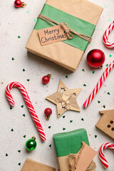 Composition with Christmas gifts, sweet candy canes and decorations on light background