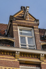Fototapeta na wymiar Old building (XVII- XVIII centuries) with gable rooftop and hook Amsterdam’s Kattenburg. Kattenburg is Island in Amsterdam that were built in second half of XVII century. Amsterdam, the Netherlands.