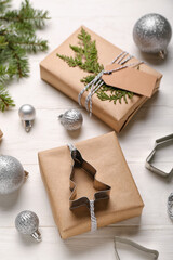 Composition with Christmas gifts and balls on light wooden background, closeup