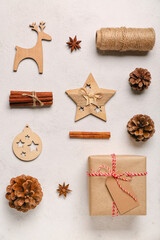 Composition with Christmas gift, cones, spices and decorations on light background