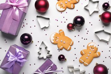 Composition with Christmas gifts, balls, cookies and cutters on light background
