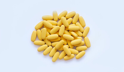 Close-up texture of yellow multivitamin tablets on white background. Healthy lifestyle concept