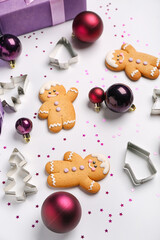 Composition with Christmas balls, cookies and cutters on light background