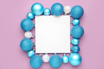 Composition with beautiful Christmas balls and blank card on lilac background